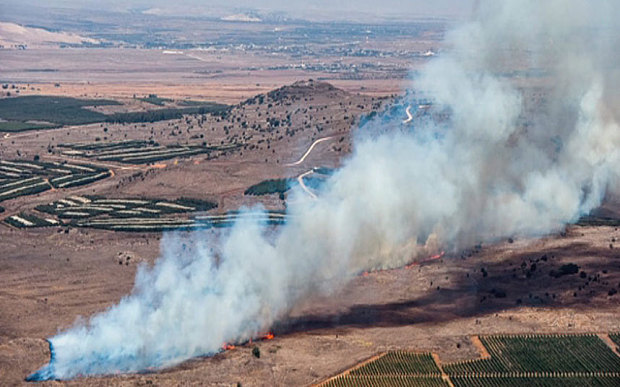 A still image from video footage shown by the HaberTurk TV Channel shows smoke billowing from what was described as the crash site of a plane after it was shot down near the Turkish-Syrian border Photo: EPA