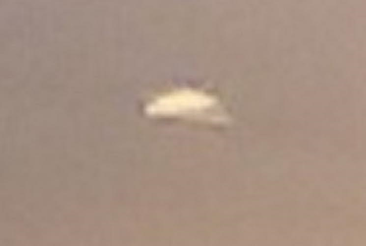 The strange craft which flew out of the back of the apparent UFO in the clouds